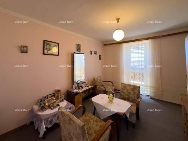 Schlaf- oder Wohnzimmer mit rosa Wänden, gemusterten Stühlen, einem Spiegel und einem Fenster.
