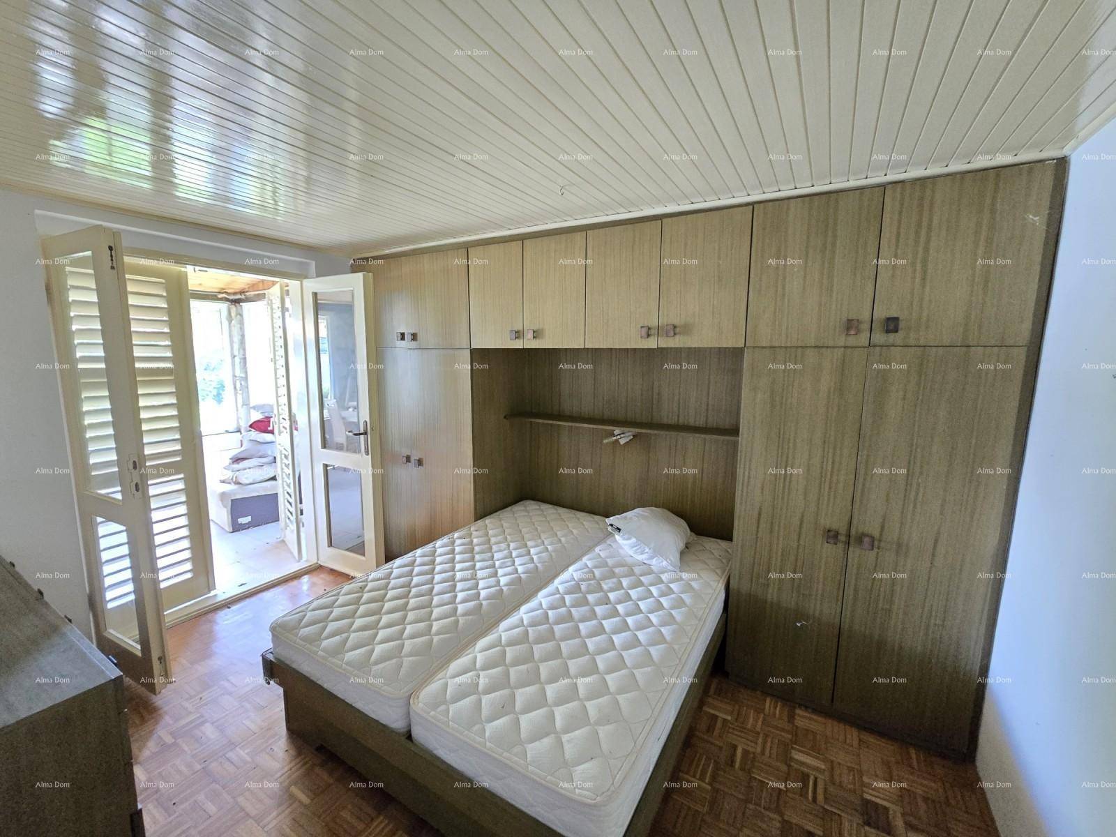 Schlafzimmer mit Einbauschränken, zwei Einzelbetten und Zugang zu einem Balkon oder einer Terrasse.