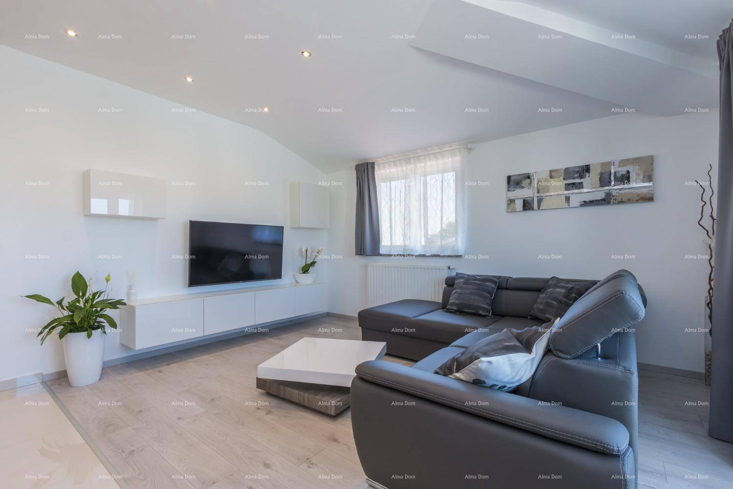 Helles Wohnzimmer mit moderner Einrichtung, Flachbildfernseher und einem großen Ecksofa.