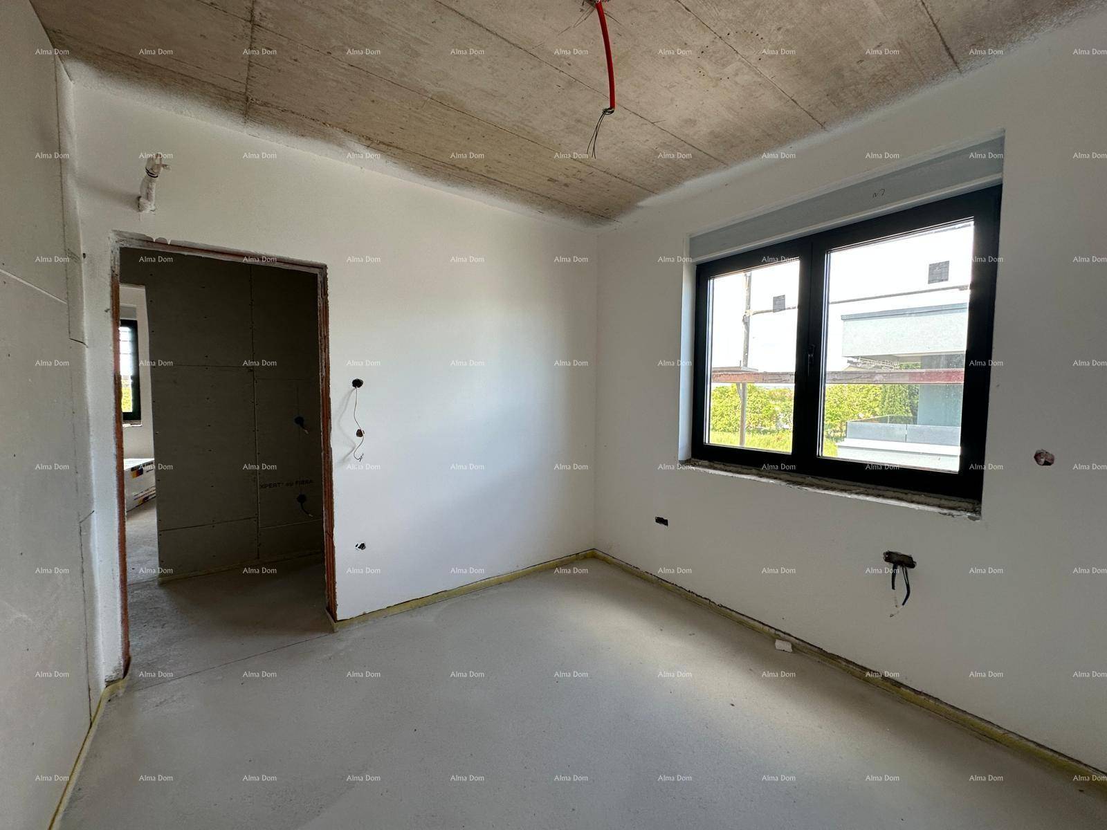 Schlafzimmer im Rohbau mit weiß gestrichenen Wänden, großem Fenster und Blick nach draußen.