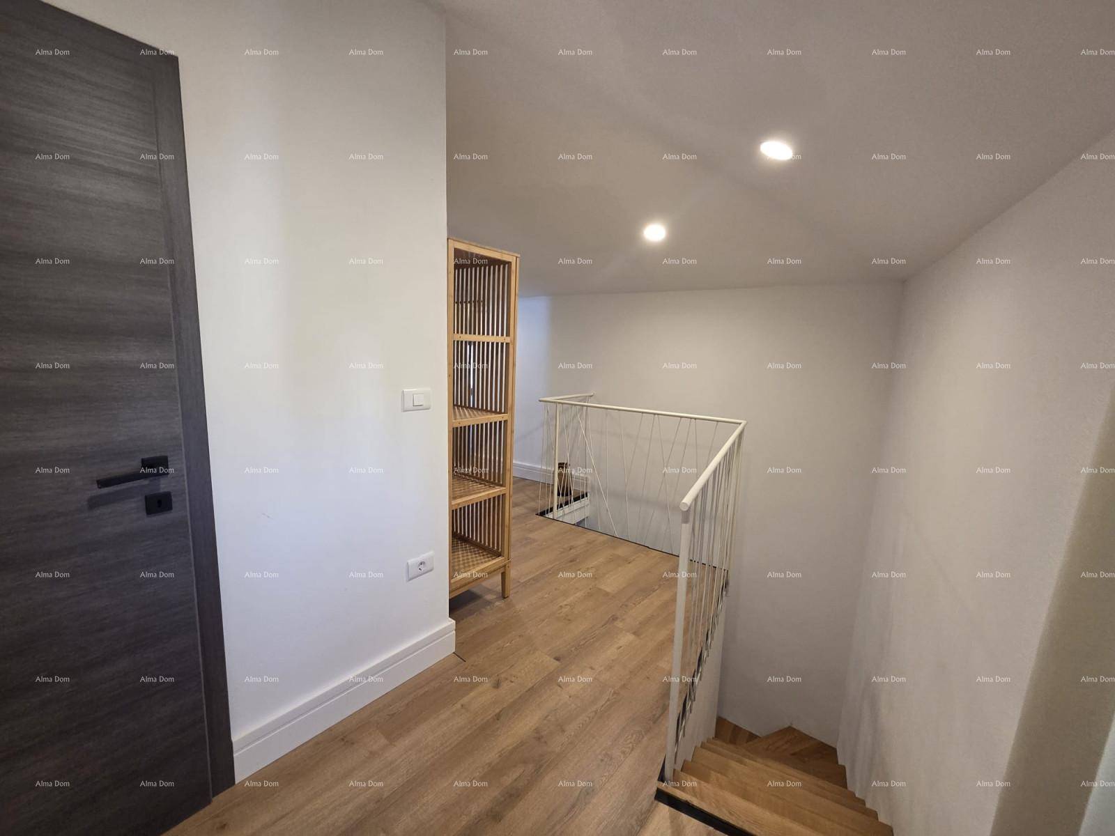 Heller Flur mit Holzfußboden, offenem Regal und einer Treppe mit modernem Geländer.
