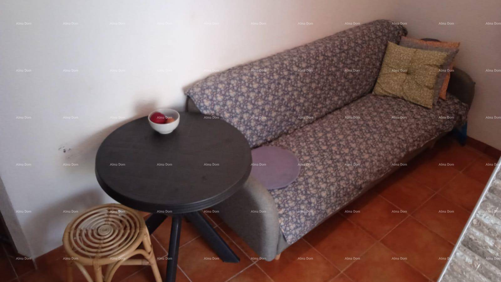 Gemütliches Schlafsofa mit kleinem Beistelltisch und Terrakottafliesen im Wohnbereich.