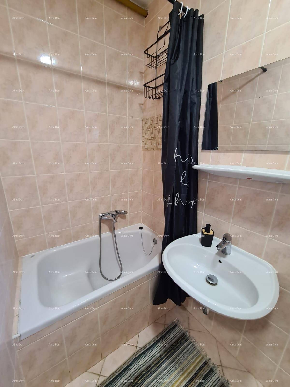 Badezimmer mit Badewanne, Waschbecken und beigefarbenen Fliesen.