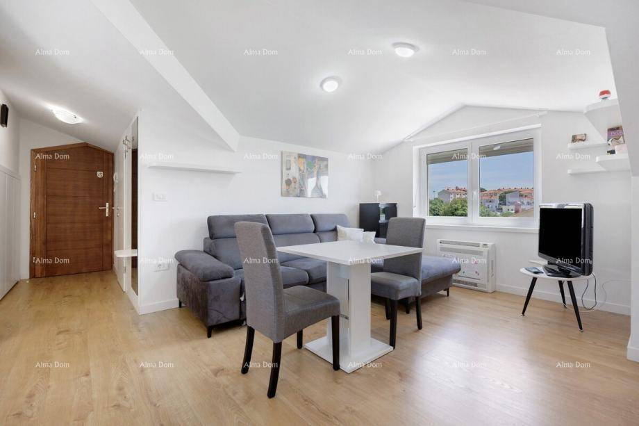 Gemütlicher Wohn- und Essbereich mit Sofa, Esstisch und Fenster, das viel Tageslicht hereinlässt.