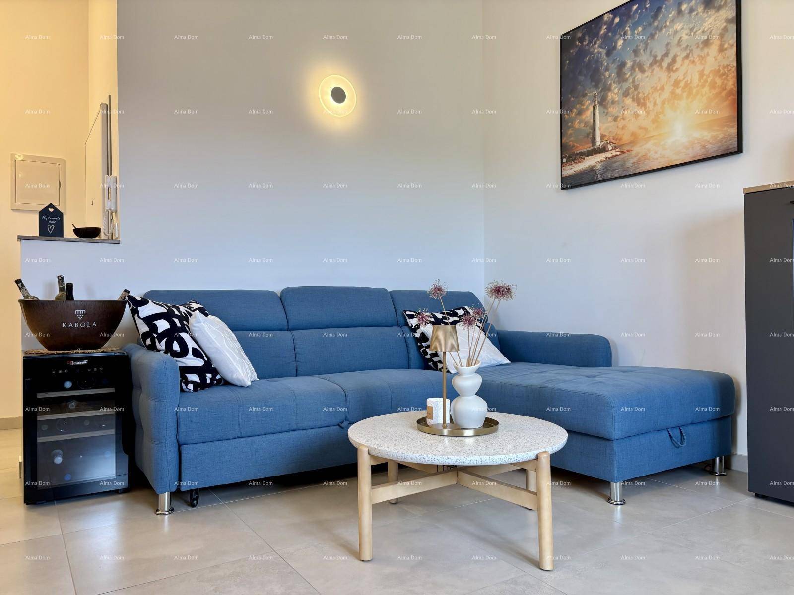 Gemütliches Wohnzimmer mit blauem Ecksofa, Couchtisch und Wanddekoration.