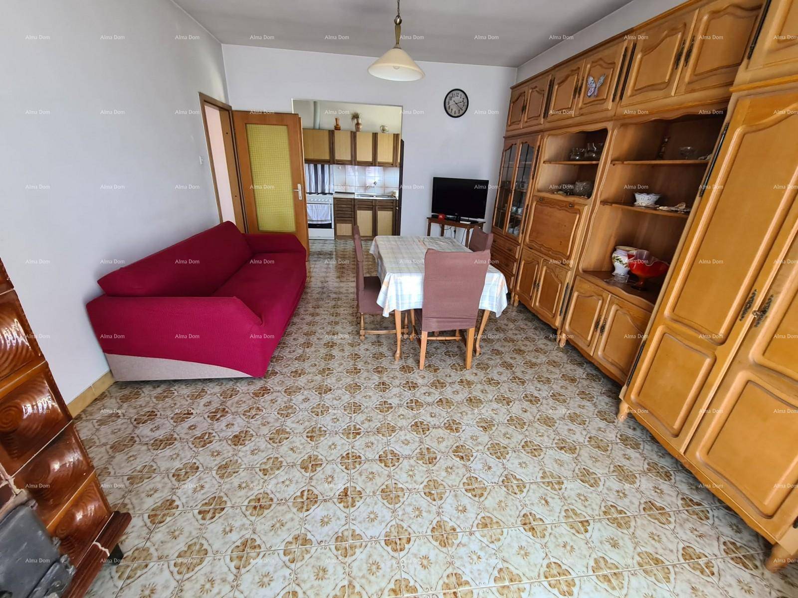 Wohn- und Essbereich mit rotem Sofa, Esstisch und großen Holzschränken, ideal für Familien.