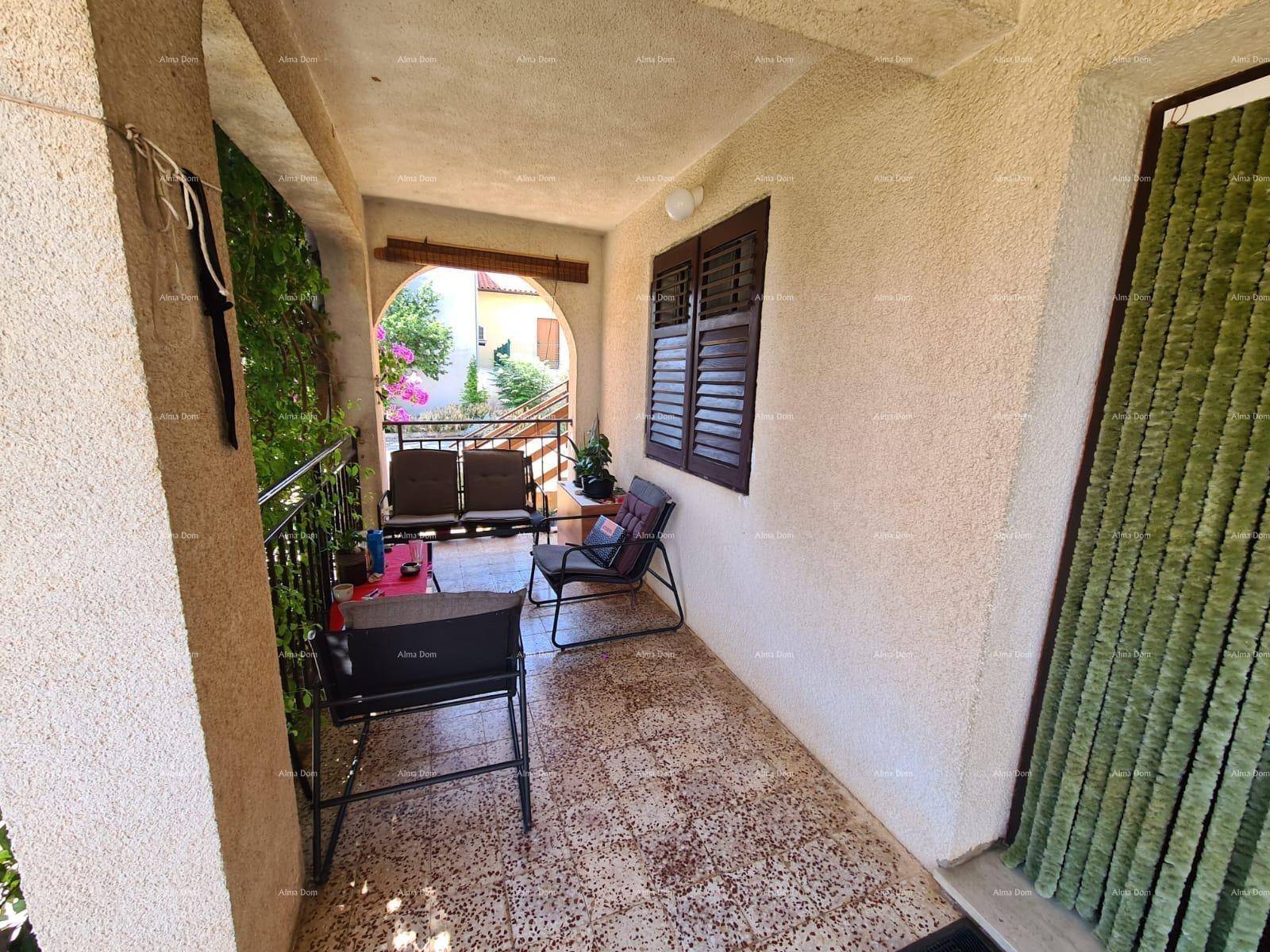 Überdachte Loggia mit Sitzgelegenheiten und Blick auf die grüne Umgebung.