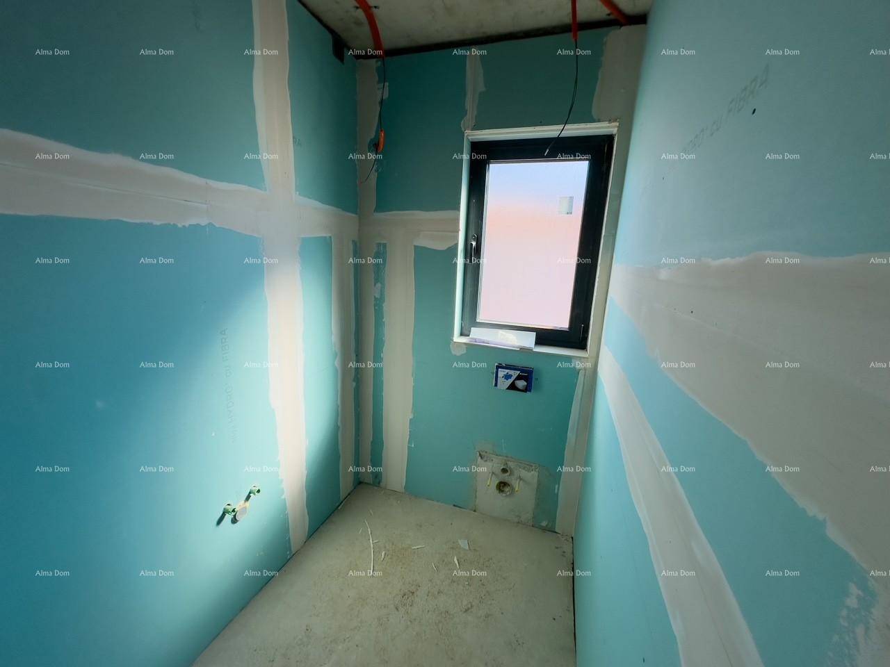 Unfertiges Badezimmer mit blauen Trockenbauwänden und einem Fenster, bereit für die Endmontage der Sanitäranlagen.