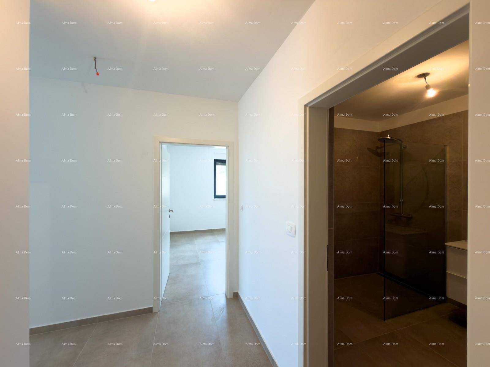 Heller Flur mit Blick in ein modernes Badezimmer und einen weiteren Raum mit Fenster.