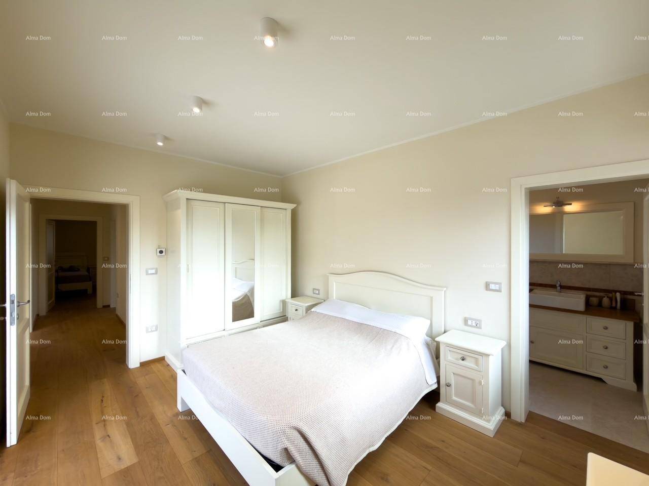 Komfortables Schlafzimmer mit Doppelbett, weißem Kleiderschrank und Zugang zu Bad und Flur.