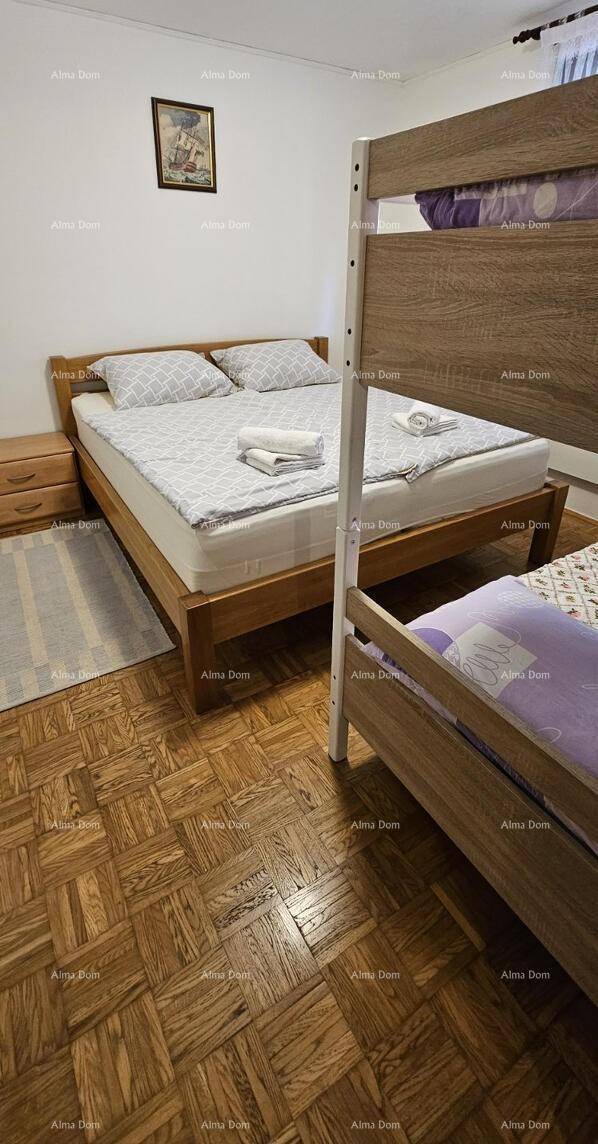 Schlafzimmer mit Doppelbett, Etagenbett und Holzboden.
