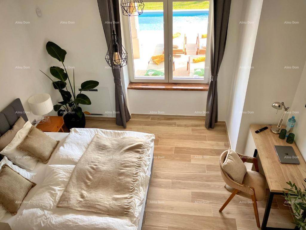 Helles Schlafzimmer mit Holzboden und Blick auf den Poolbereich.