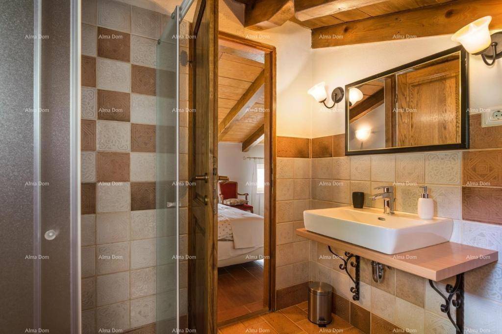 Badezimmer mit Duschkabine, Einzelwaschbecken und gemusterten Fliesen.
