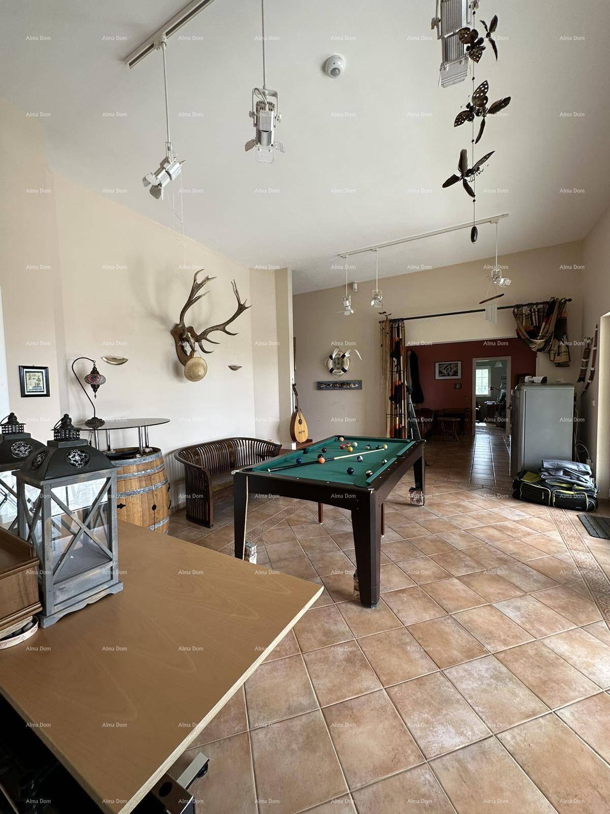 Großer Freizeitraum mit Billardtisch, Geweihdekoration und Fliesenboden.