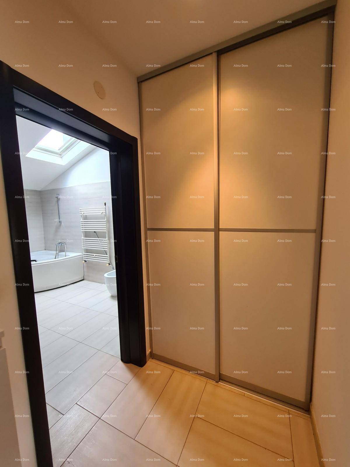 Heller Flur mit Schiebetüren und Blick auf ein Badezimmer mit Eckbadewanne.