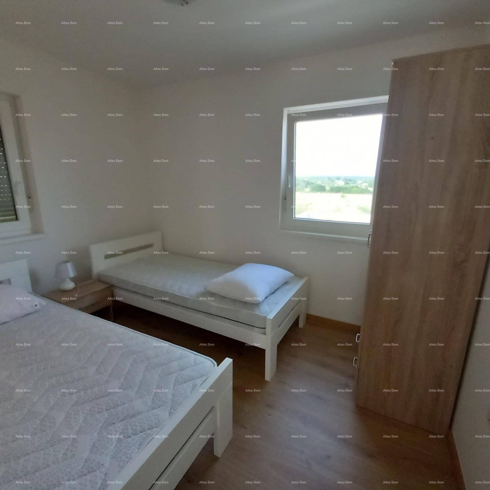 Helles Schlafzimmer mit zwei Einzelbetten, Holzfußboden, einem Fenster und einem Kleiderschrank.