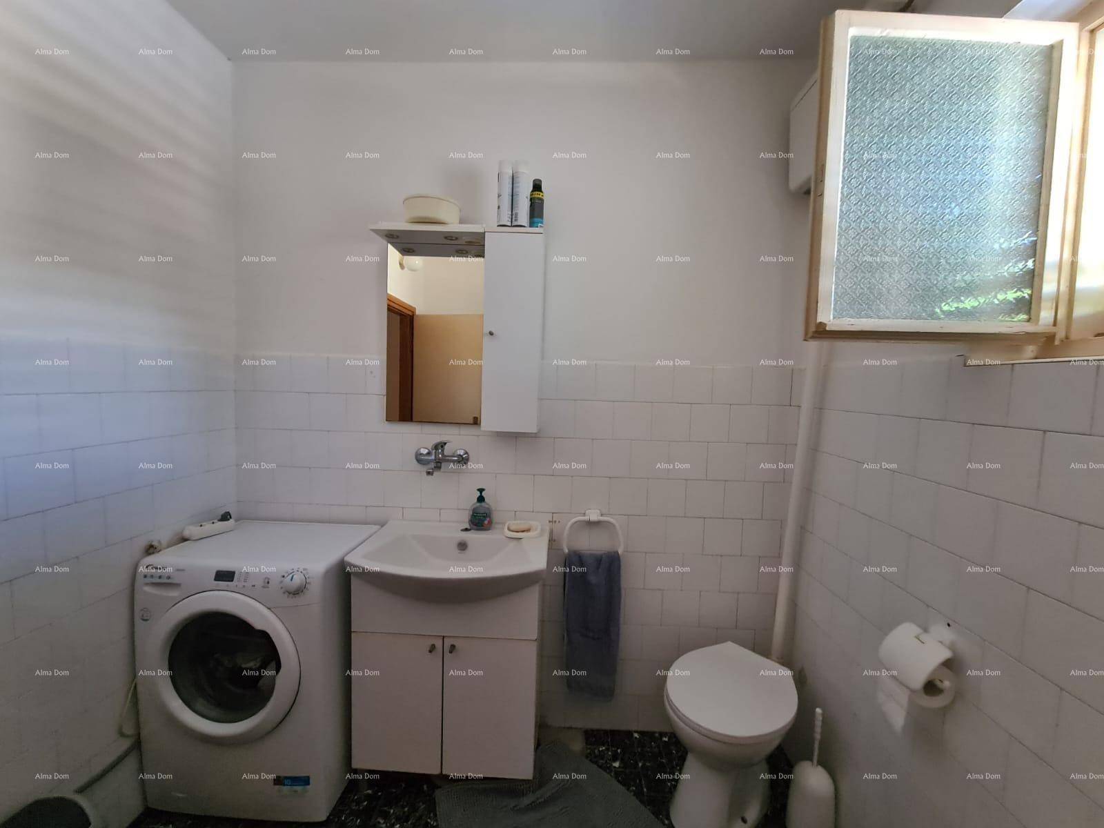 Helles Badezimmer mit Waschbecken, Toilette und Waschmaschine, ausgestattet mit weißen Wandfliesen.