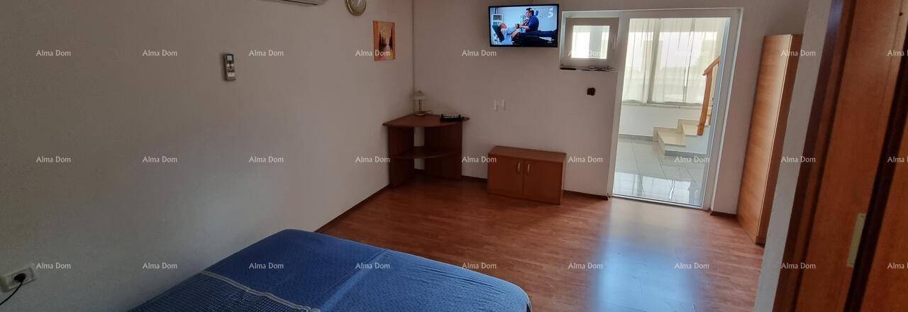 Schlafzimmer mit Bett, Fernseher und Zugang zu einem anderen Bereich oder Treppenhaus.