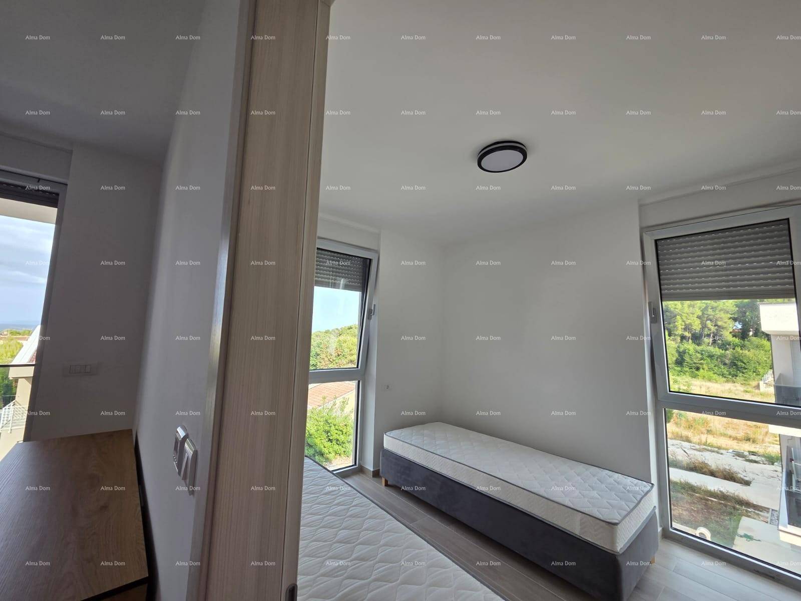 Schlafzimmer mit zwei Einzelbetten und großen Fenstern, die viel Tageslicht hereinlassen.