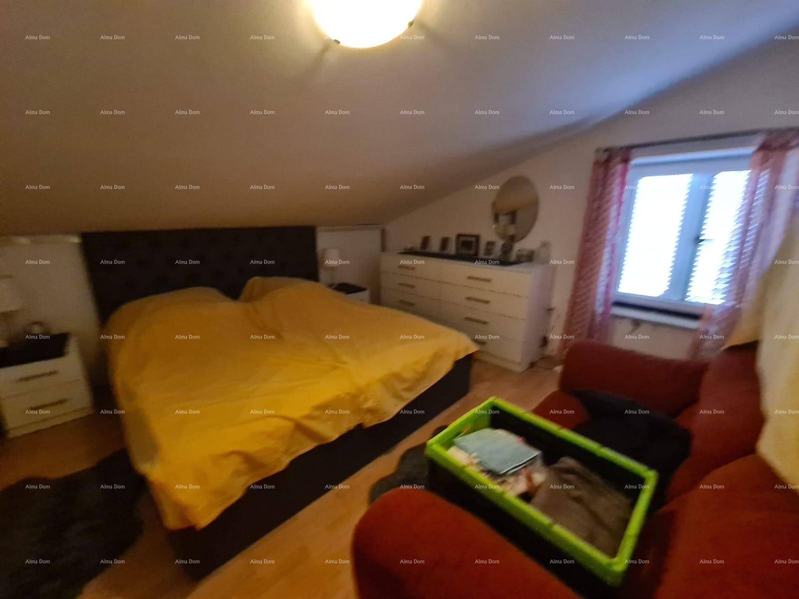 Gemütliches Schlafzimmer im Dachgeschoss mit Doppelbett, Kommode und schrägen Wänden.