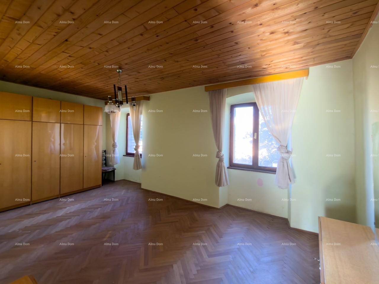 Geräumiges Schlafzimmer mit Holzdecke, Parkettboden und großem Kleiderschrank, hell durch zwei Fenster.