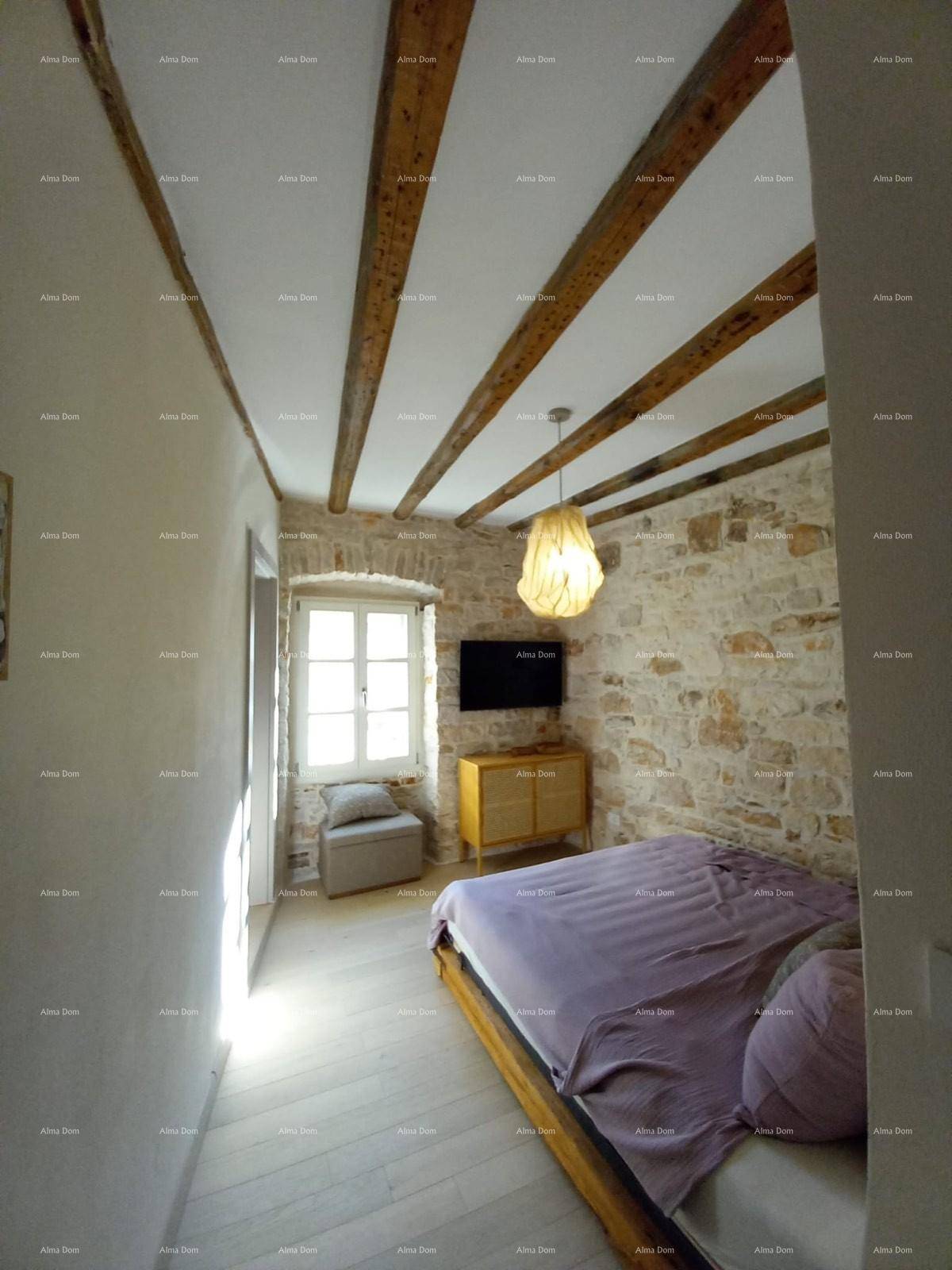 Helles Schlafzimmer mit Steinwand, Holzbalkendecke und Klimaanlage für angenehmes Raumklima.