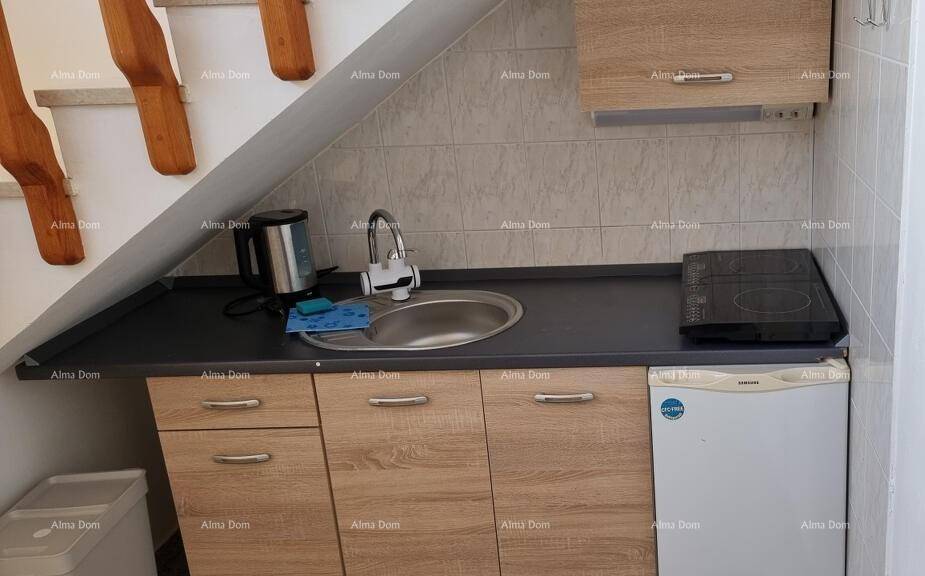 Kompakte Küchenzeile unter der Treppe mit Spüle, Kochfeld und Kühlschrank.
