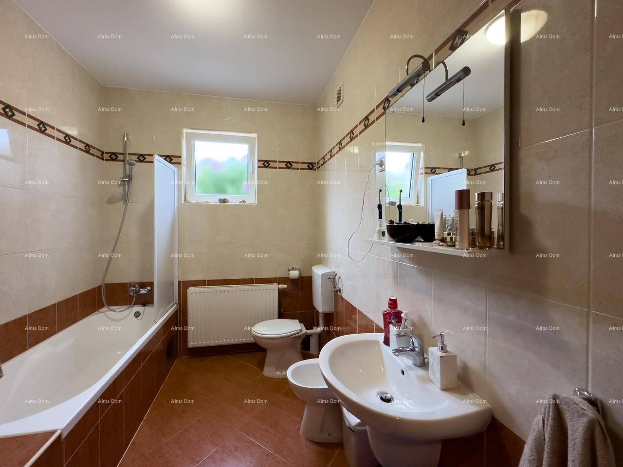 Badezimmer mit Badewanne, WC, Bidet und Fenster für natürliche Belüftung, hell gefliest.