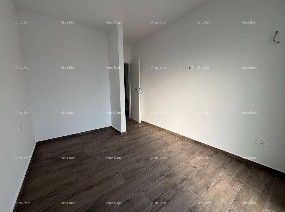 Schlichtes, leeres Zimmer mit dunklem Fliesenboden und weißen Wänden, bereit zur individuellen Gestaltung.