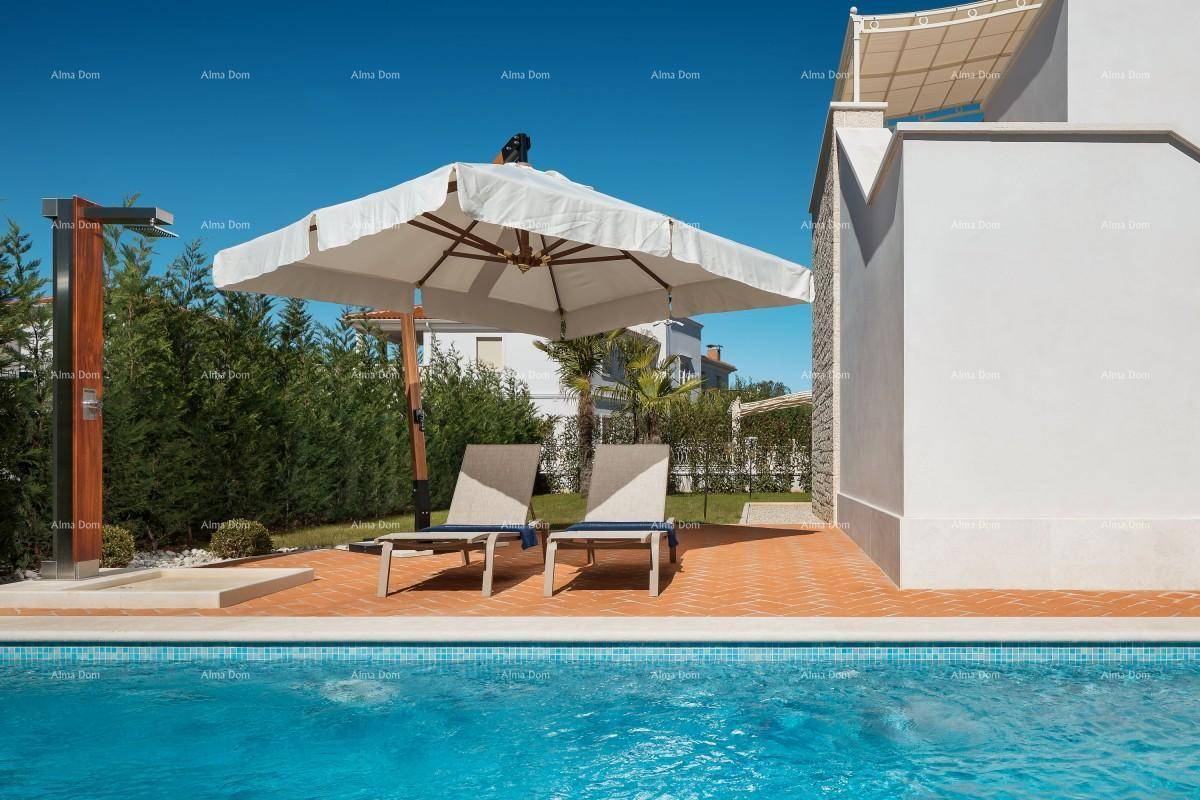 Sonniger Poolbereich mit Liegestühlen, großem Sonnenschirm und Außendusche.