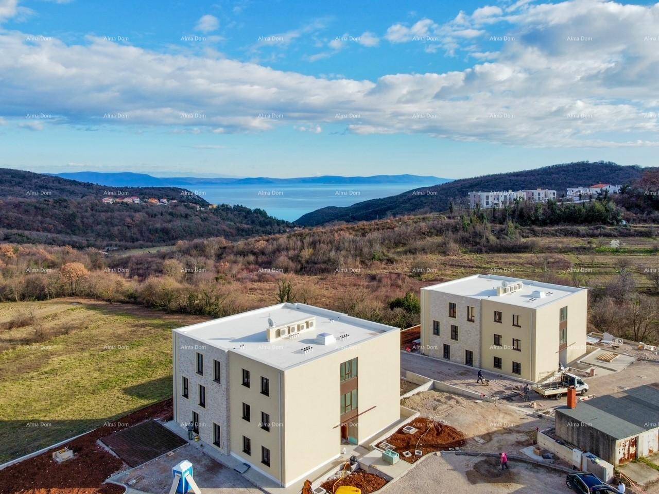 Luftaufnahme von zwei Neubauten in hügeliger Landschaft mit weitem Meerblick.