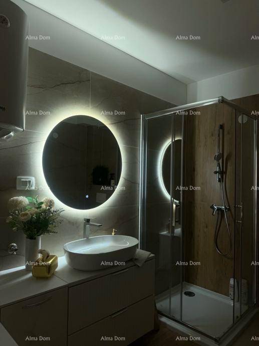 Modernes Badezimmer mit beleuchtetem Spiegel, Aufsatzwaschbecken und einer Duschkabine.