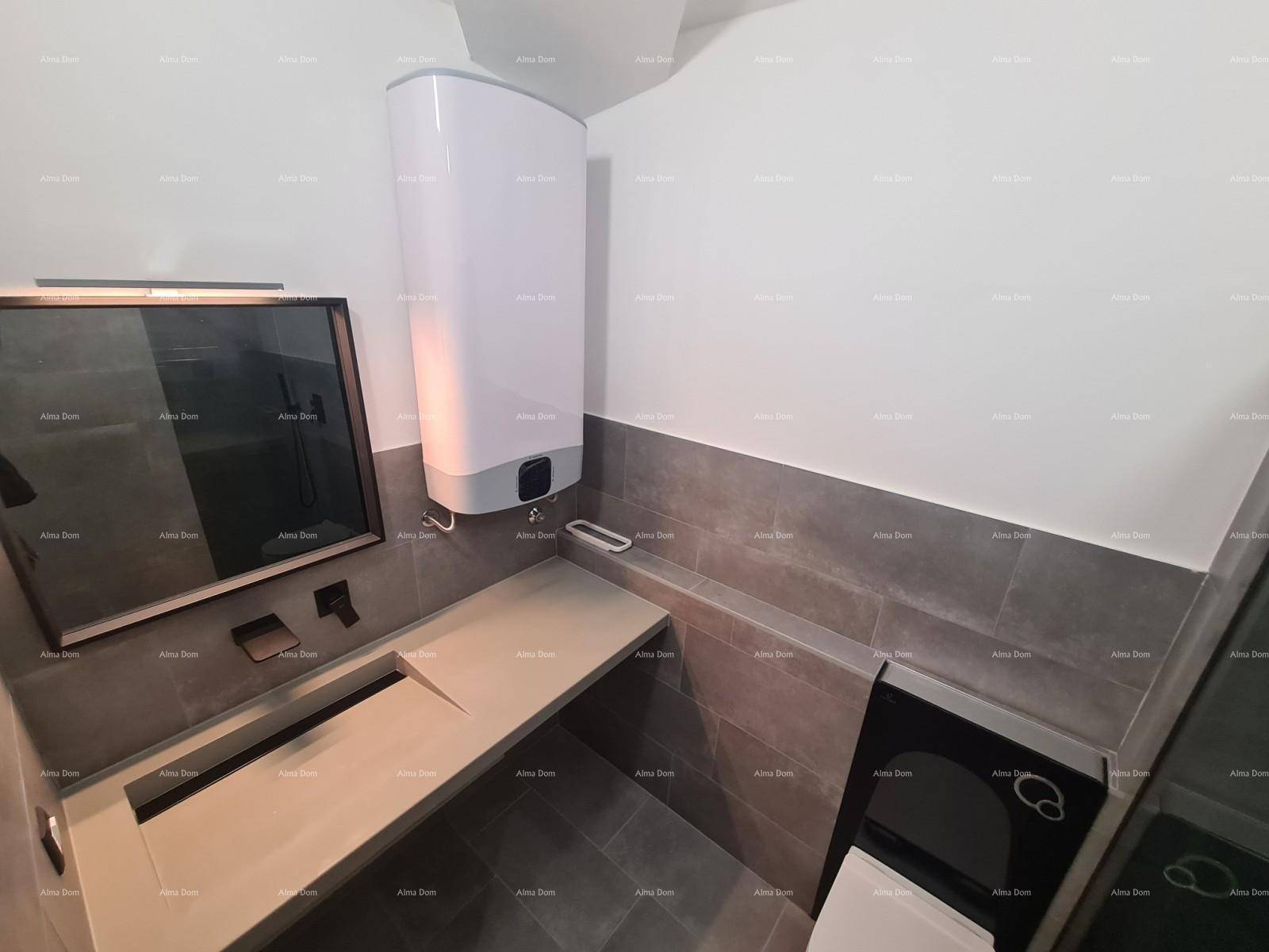 Modernes Badezimmer mit grauen Fliesen, Waschbecken und einem Warmwasserbereiter.