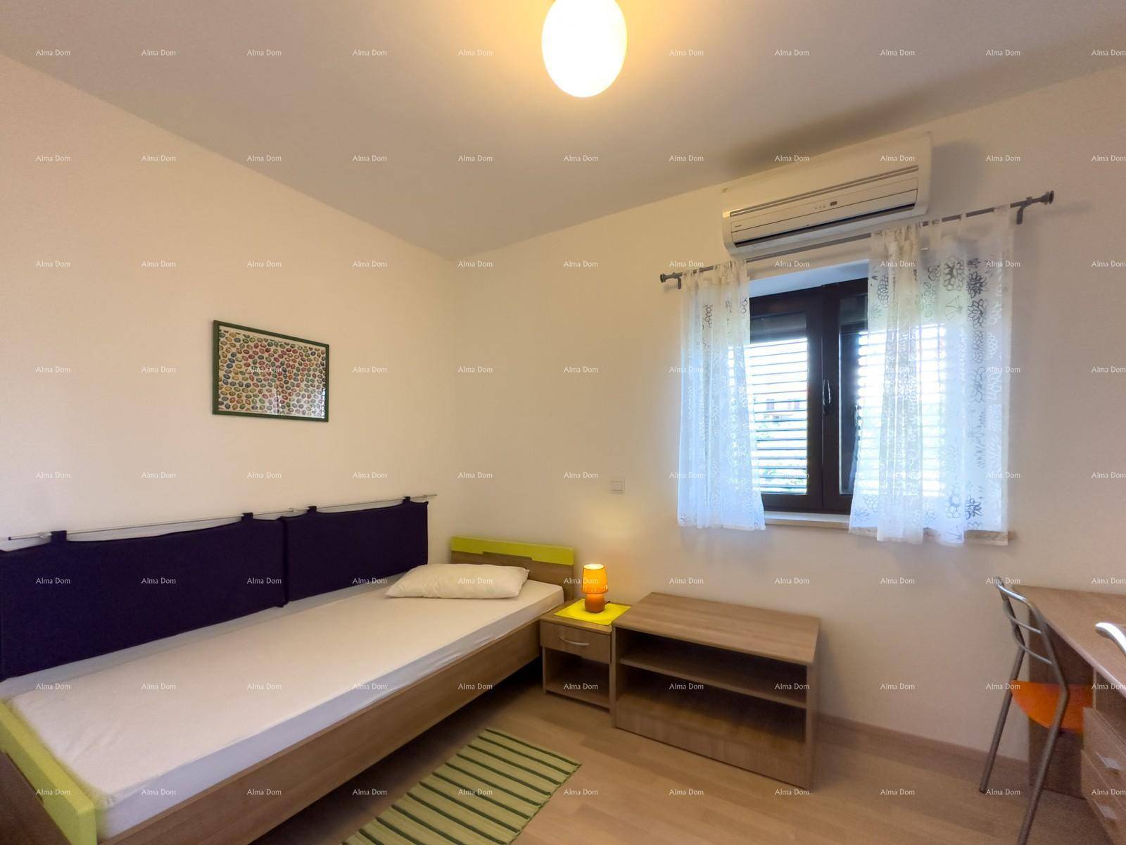 Helles Schlafzimmer mit Einzelbett, Klimaanlage und einem Schreibtischbereich am Fenster.