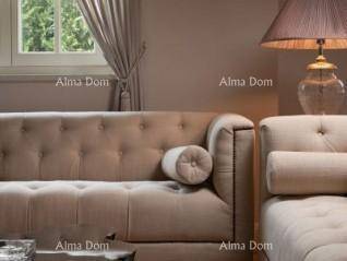 Detailansicht eines eleganten, gepolsterten Sofas mit einer klassischen Stehlampe im Wohnbereich.