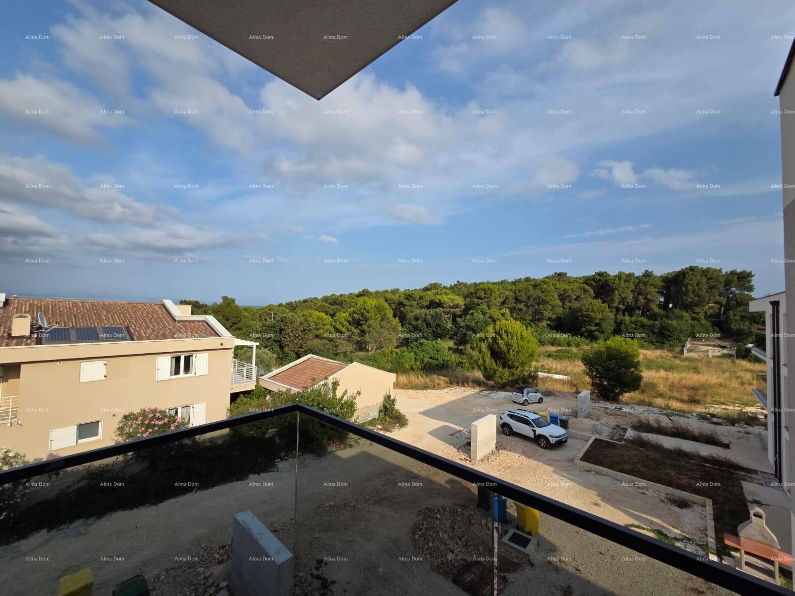 Geräumiger Balkon mit Panoramablick auf grüne Bäume und das Meer in der Ferne.