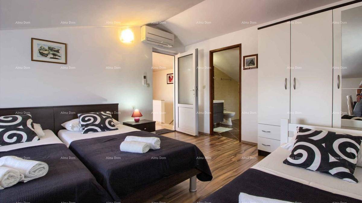 Schlafzimmer mit mehreren Einzelbetten, Kleiderschrank und Zugang zu einem Badezimmer.