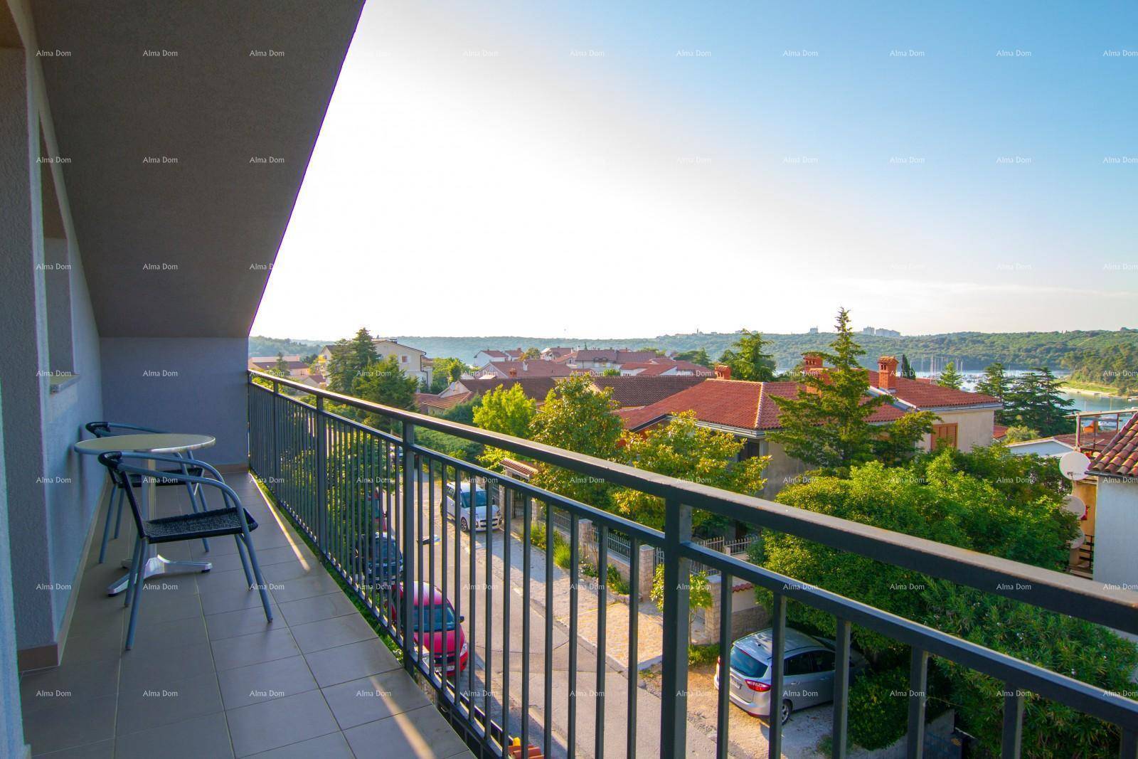 Balkon mit Metallgeländer und Blick auf die umliegende Wohnsiedlung und das Meer in der Ferne.