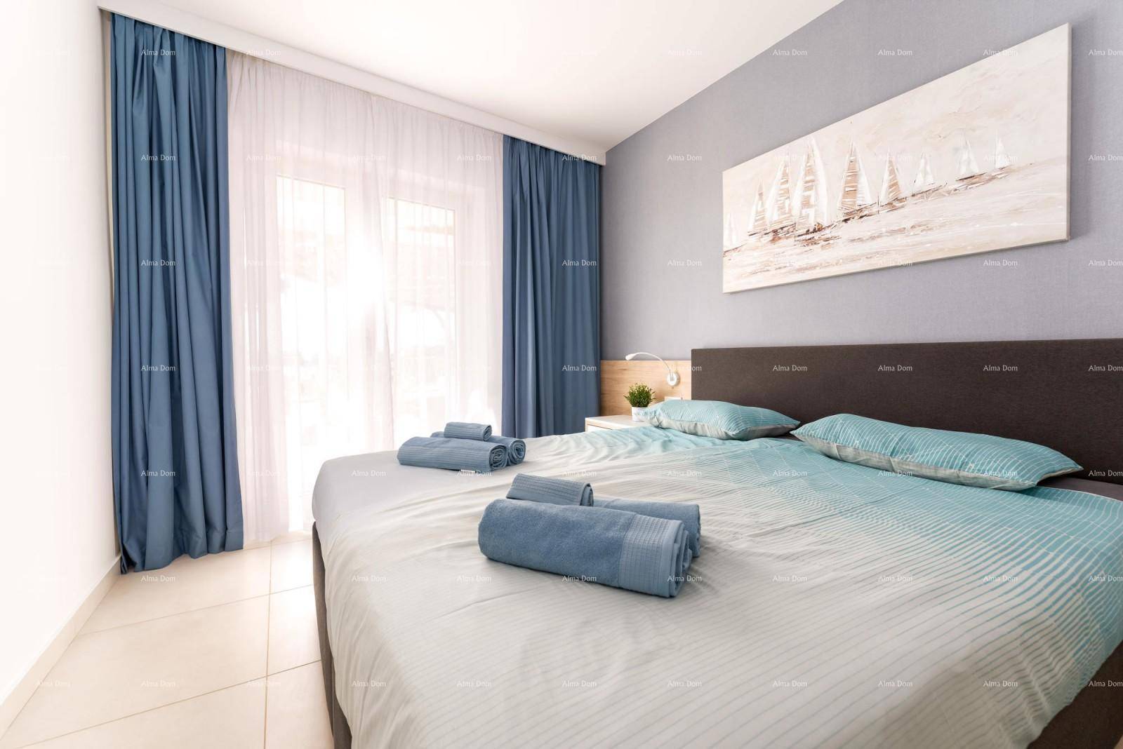 Modernes Schlafzimmer mit bequemen Bett, blauen Vorhängen und viel Tageslicht.