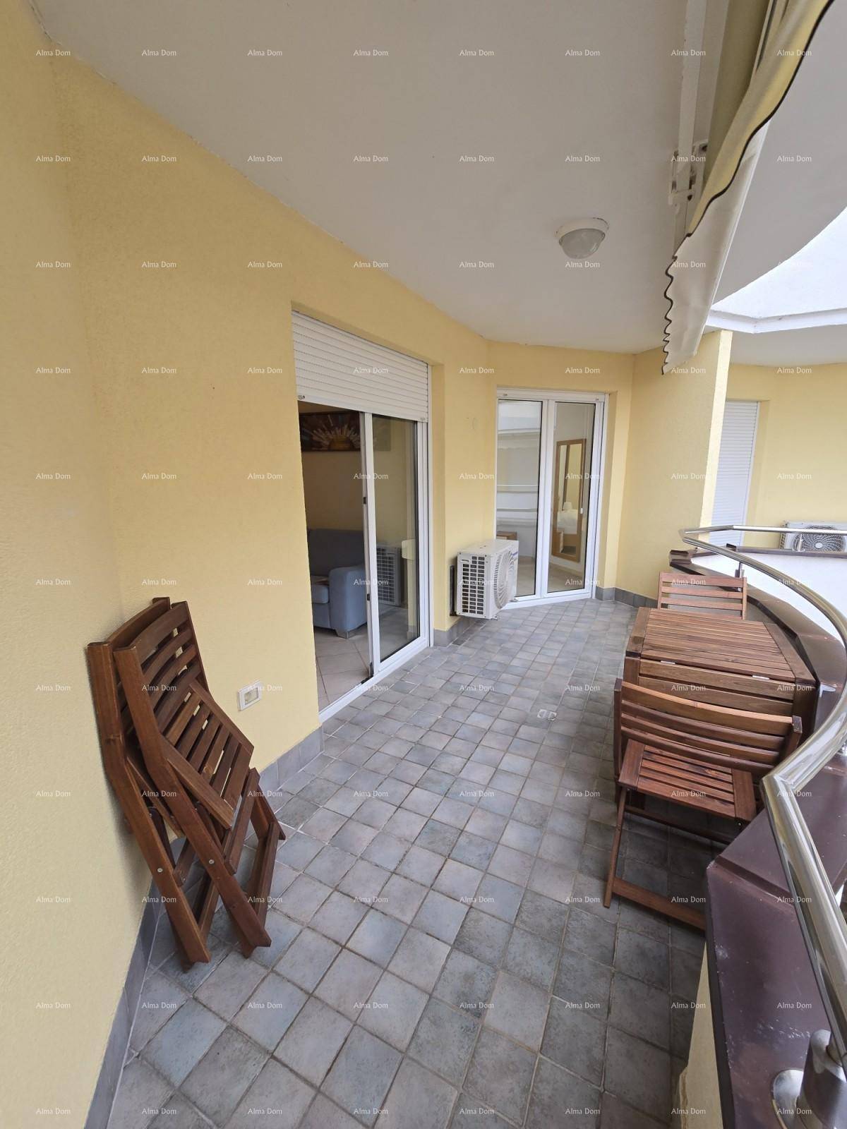 Langer Balkon mit Fliesenboden und Holzmöbeln, zugänglich von den Innenräumen für vielseitige Nutzung.