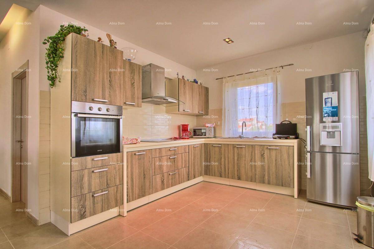 Moderne Küche mit Holzschränken, integriertem Backofen und großem Kühlschrank.