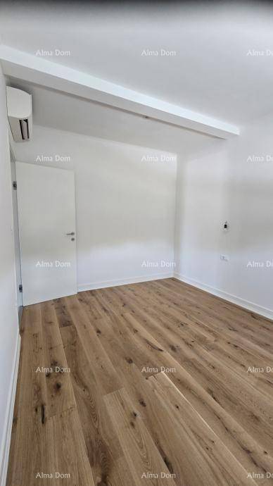 Geräumiges Schlafzimmer mit Holzboden, weiß gestrichenen Wänden und Klimaanlage.