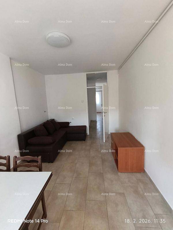 Wohn- und Essbereich mit Sofa, Fliesenboden und offenem Zugang zu weiteren Räumen.