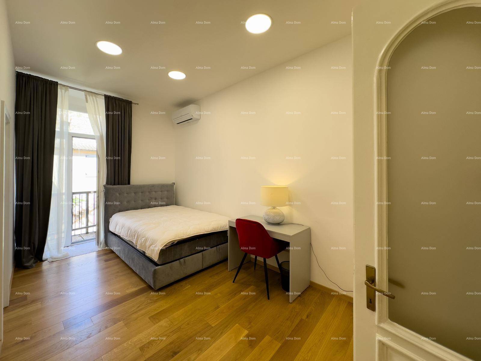 Schlafzimmer mit Holzboden, Schreibtisch und Zugang zu einem kleinen Balkon, ideal für Home-Office.