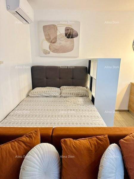 Schlafzimmer mit Doppelbett, Klimaanlage und moderner Wandkunst über dem Kopfteil.