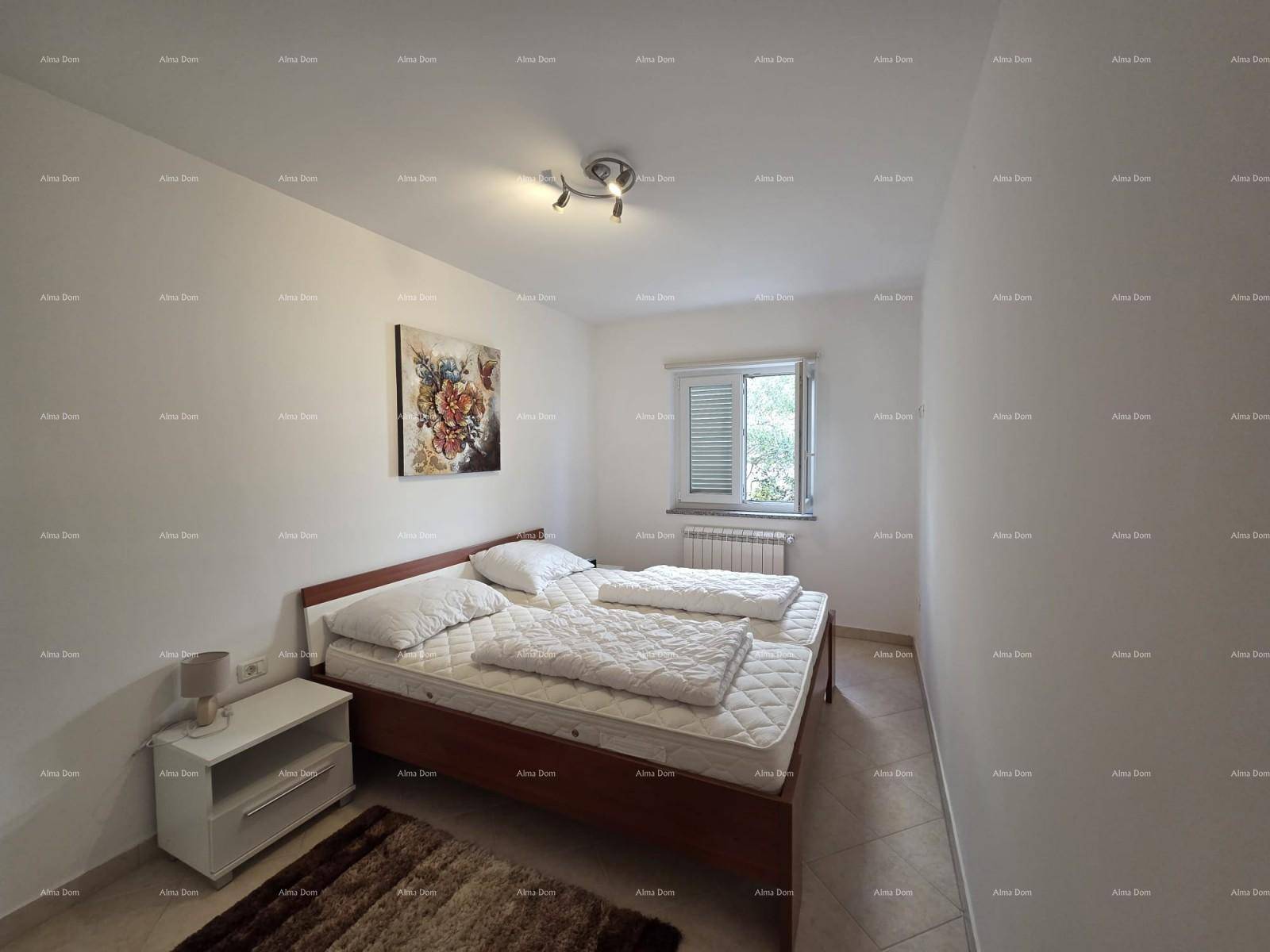 Schlafzimmer mit Doppelbett, Nachttisch und einem Fenster, das Tageslicht hereinlässt.