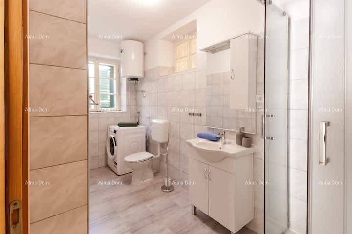 Modernes Badezimmer mit Duschkabine, WC, Waschbecken, Waschmaschine und Fenster.