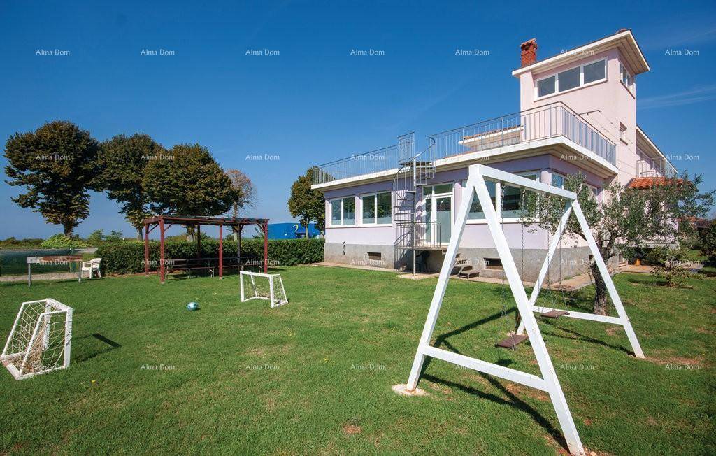 Großer grüner Garten mit Schaukel, Fußballtoren und mediterranen Bäumen.