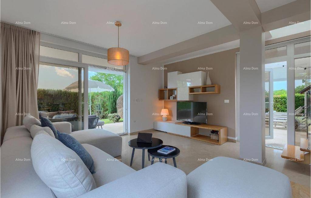 Helles Wohnzimmer mit beigem Sofa, modernem TV-Möbel und großen Fenstern mit Zugang zur Terrasse.