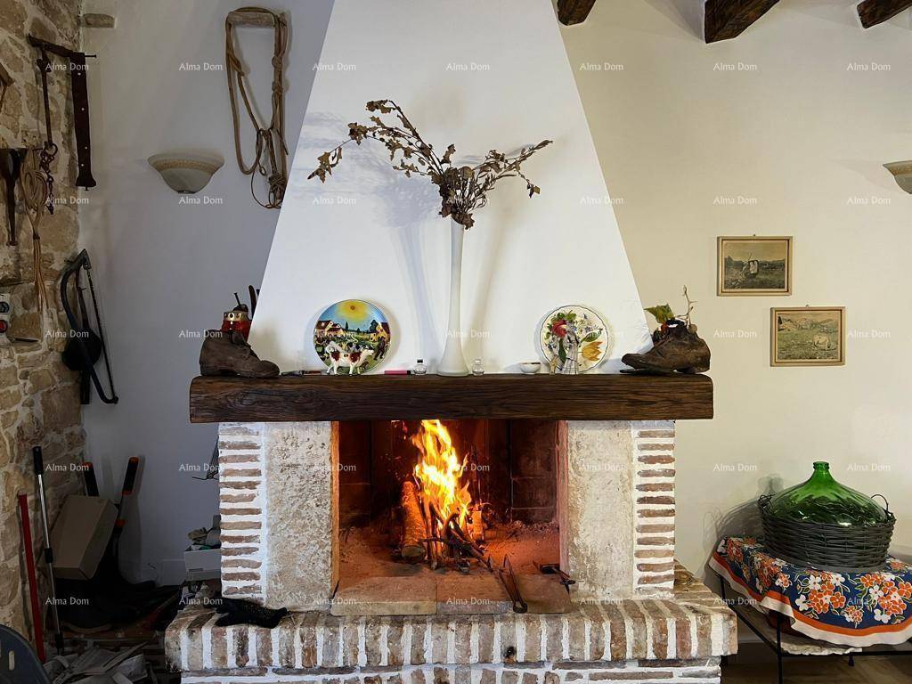 Gemütliches Wohnzimmer mit rustikalem Kamin, Holzbalken und Steinwandakzenten.